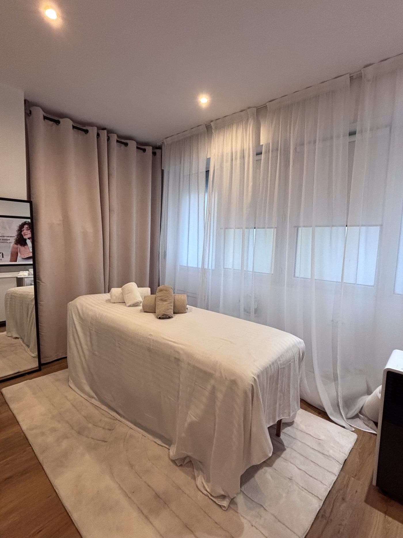 The treatment room at La Maison Feï: a massage table draped in white, with sheer curtains